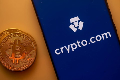 A Bitcoin and Crypto.com logo on a blue screen representing cryptocurrency