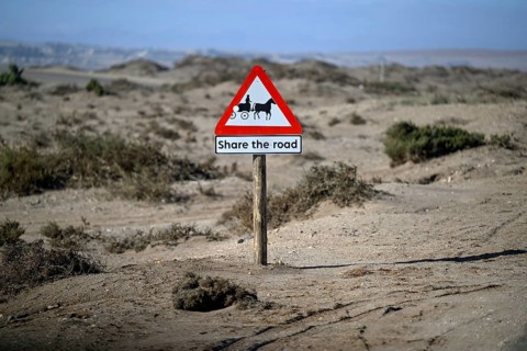 Sign Caution carriages on a road near Oranjemund, diamond restricted area, Karas region, Namibia