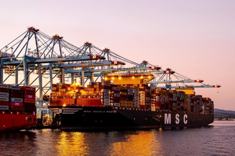 Gibraltar, UK - December 26, 2023: Container ship in the port during sunset