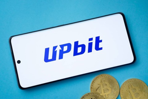 Dhaka, Bangladesh- 19 Sep 2025: Upbit logo on smartphone screen near Bitcoin coin and QR code on