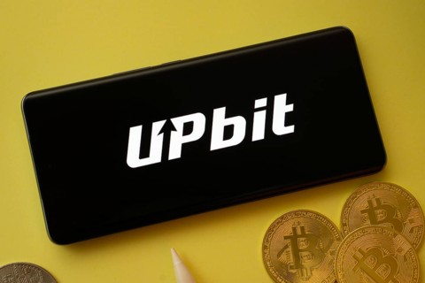 Dhaka, Bangladesh- 19 Sep 2025: Upbit logo on smartphone screen near Bitcoin coin and QR code on