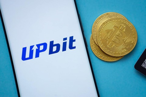 Dhaka, Bangladesh- 26 Aug 2025: Upbit logo on smartphone screen near Bitcoin coin and QR code on