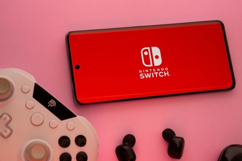Dhaka, Bangladesh- 15 July 2025: Smartphone with nintendo switch logo, game controller, and earbuds