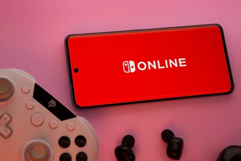 Dhaka, Bangladesh- 15 July 2025: Smartphone with nintendo online logo, game controller, and earbuds