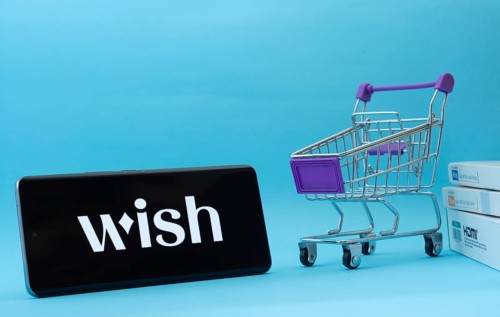 Dhaka, Bangladesh- 03 July 2025: Smartphone with Wish logo next to a small shopping cart and boxes