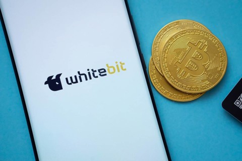 Dhaka, Bangladesh- 03 Sep 2025: Whitebit logo on smartphone screen near Bitcoin coin and QR code on