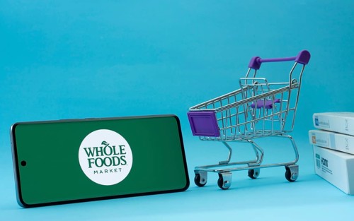 Dhaka, Bangladesh- 03 July 2025: Smartphone with Whole Foods Market logo next to a small shopping