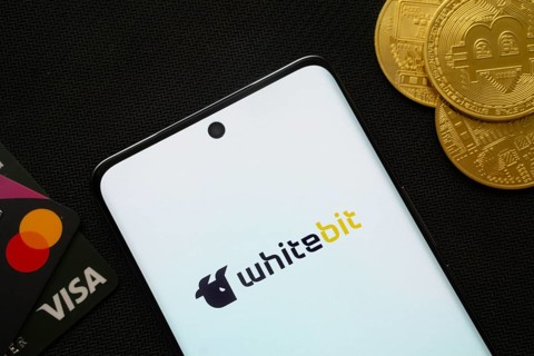 Dhaka, Bangladesh- 15 June 2025: Smartphone displaying whitebit logo surrounded by Bitcoin coins
