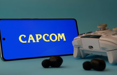 Dhaka, Bangladesh- 19 Sep 2025: A smartphone with a Capcom icon next to a controller and earbuds on