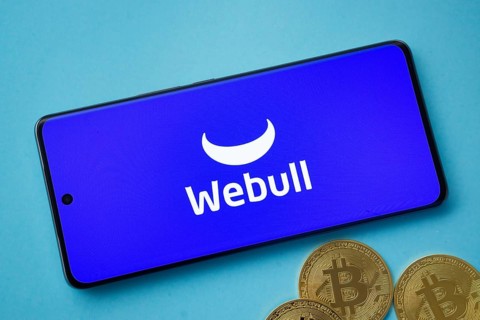 Dhaka, Bangladesh- 03 Sep 2025: webull logo on smartphone screen near Bitcoin coin and QR code on