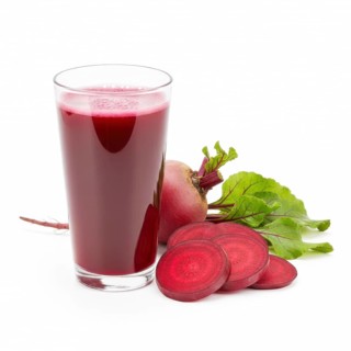 A refreshing glass of vibrant red beetroot juice is presented alongside sliced and whole beets,