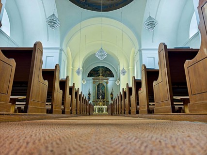 Church interior with view of the altar, wooden benches and quiet atmosphere, Kammersdorf Hollabrunn
