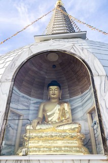 Golden Buddha statue in a stupa, meditating, surrounded by glass protection, Stupa am Wagram