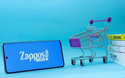 Dhaka, Bangladesh- 03 July 2025: Smartphone with Zappos logo next to a small shopping cart and