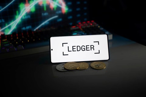 Ledger screen with coins, positioned before a stock chart, lit by neon lights