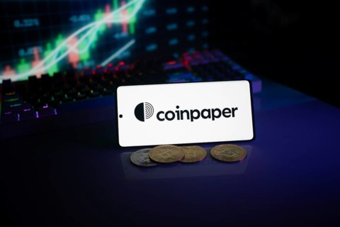 Coinpaper display with coins against a stock chart backdrop illuminated by neon lights