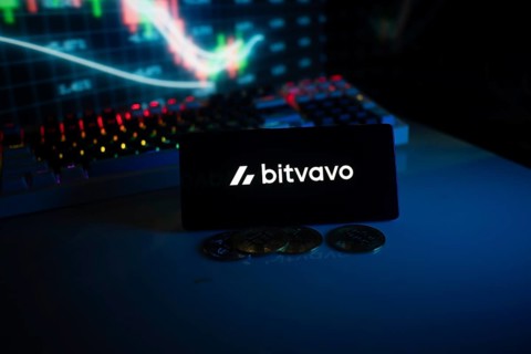 Bitvavo display with coins in front of a lit stock chart in blue neon ambiance