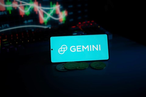 Gemini logo displayed amid coins and glowing trading charts, suggesting modern finance themes
