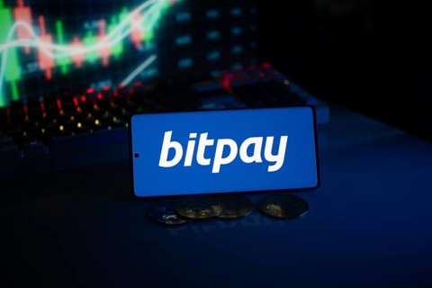 Bitpay logo presented with coins and glowing market graphs, reflecting digital commerce