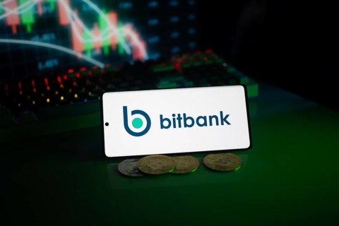Bitbank logo displayed with coins and market charts, surrounded by neon lighting