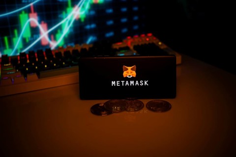 Phone displaying MetaMask with fox logo near coins and market data, linked to crypto use