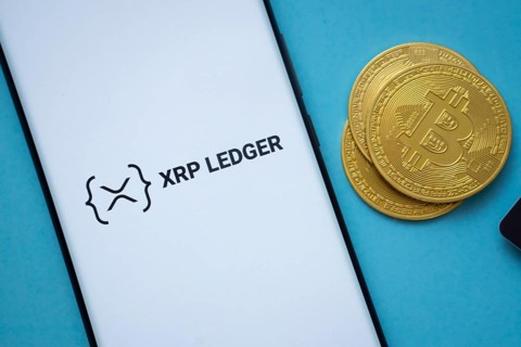 Dhaka, Bangladesh- 26 Aug 2025: XRP Ledger logo on smartphone screen near Bitcoin coin and QR code