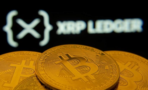 Dhaka, Bangladesh- 27 July 2025: Close-up of Bitcoin coins with the XRP Ledger logo visible on a
