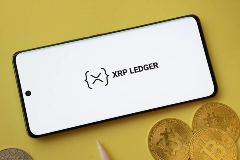 Dhaka, Bangladesh- 26 Aug 2025: XRP Ledger logo on smartphone screen near Bitcoin coin and QR code