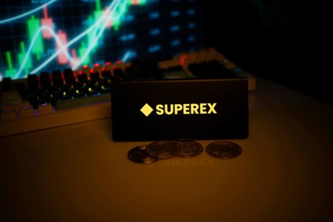 SUPEREEX logo on a smartphone with coins and financial display in the background