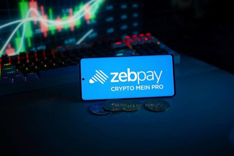 Zebpay logo on a phone with digital currencies and financial trading graphs in the background