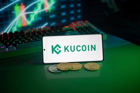KuCoin logo on smartphone with coins, green neon lights, and trading charts in background