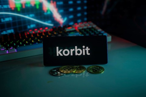 Korbit logo with cryptocurrency coins and market graph in neon-lit setting