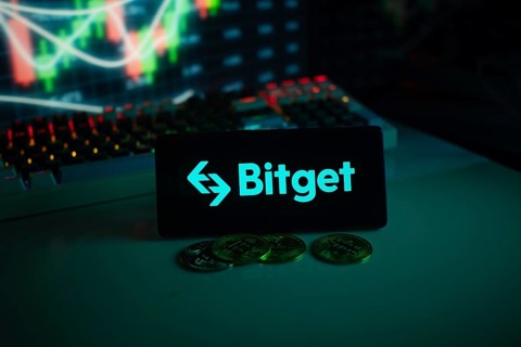 Bitget logo on black screen with coins and trading graphs in the background
