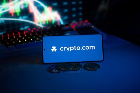 Crypto.com logo with coins and dynamic market graph in blue-lit setting