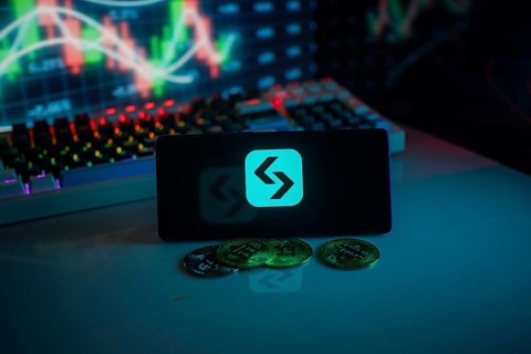 Cryptocurrency logo and coins set against a market graph in a neon setting