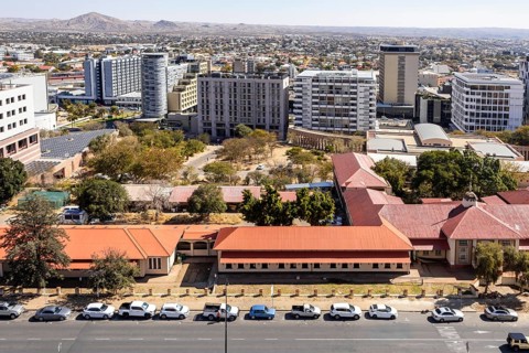 Modern downtown Windhoek, Namibia, with tall contemporary buildings, wide streets, moving cars, and