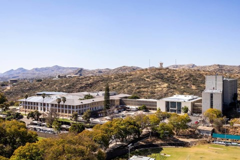 Modern downtown Windhoek, Namibia, with tall contemporary buildings, wide streets, moving cars, and