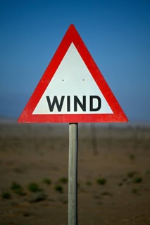 Caution wind sign on a road near Oranjemund, diamond restricted area, Karas region, Namibia