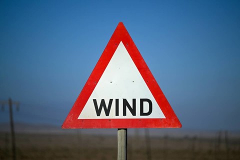 Caution wind sign on a road near Oranjemund, diamond restricted area, Karas region, Namibia