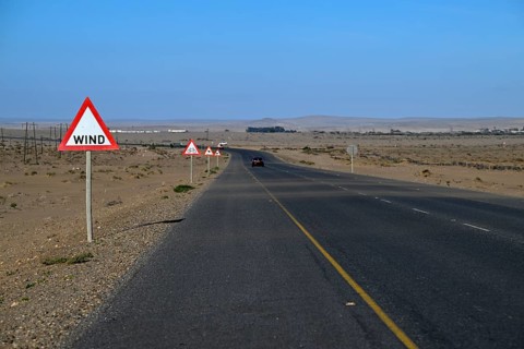 Caution wind sign on a road near Oranjemund, diamond restricted area, Karas region, Namibia