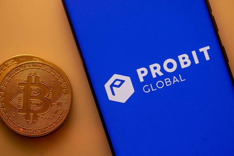 Bitcoin besides a smartphone displaying Probit Global app on blue background