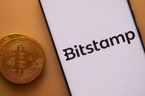 Bitstamp logo on white screen beside Bitcoin, indicating crypto trading platform