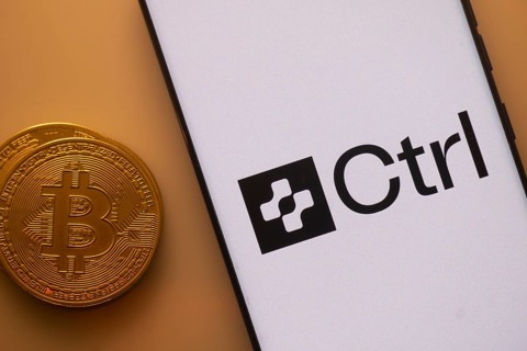 Bitcoin and Ctrl logo displayed on a smartphone with orange ambient lighting