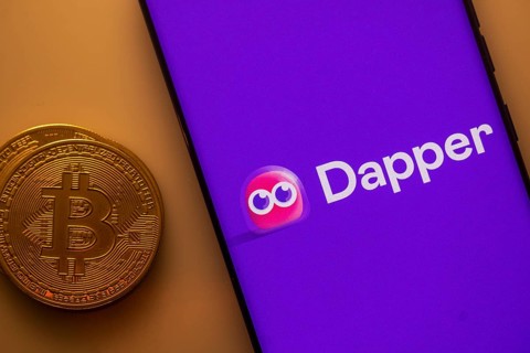 Dapper logo displayed on a smartphone next to a Bitcoin coin