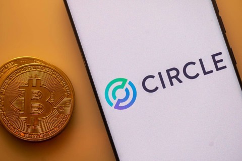 Bitcoin coin beside a white phone screen displaying the Circle logo