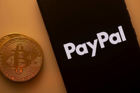 PayPal logo on smartphone screen next to Bitcoin, highlighting digital payments and financial