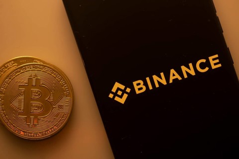 Bitcoin coin with Binance logo on a black background, linking to digital currency trading
