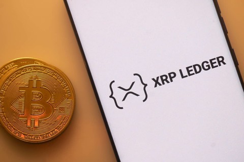 XRP Ledger logo on smartphone next to Bitcoin, emphasizing blockchain and cryptocurrency exchange