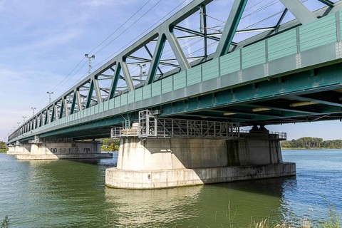 Modern metal bridge over a river with solid architecture and wet structures, old Danube bridge