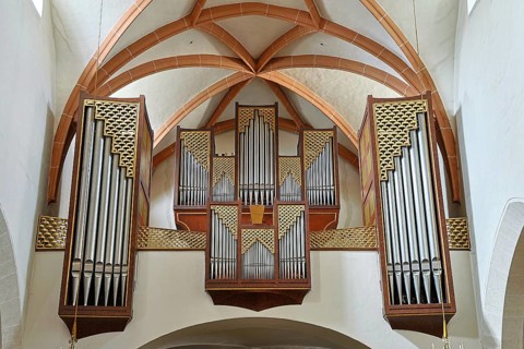 Close-up of an impressive church organ with ornate wooden details and arch structures, parish
